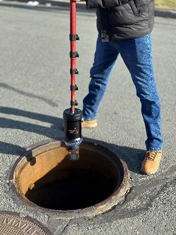 RV-MAX 360 camera on a pole lowered into a manhole